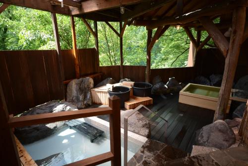 a bath room with a tub and a bath tub at Hotel Manyotei in Nikko