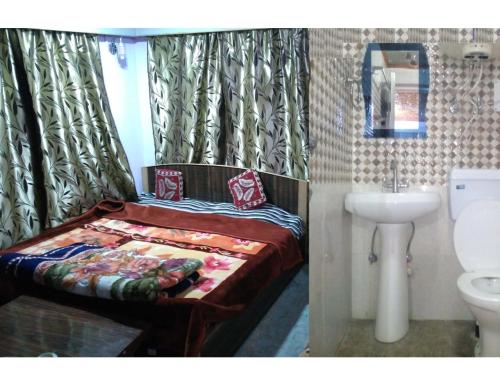 Gulab Resort, Srinagar في سريناغار: غرفة نوم بسرير ومغسلة ومرحاض