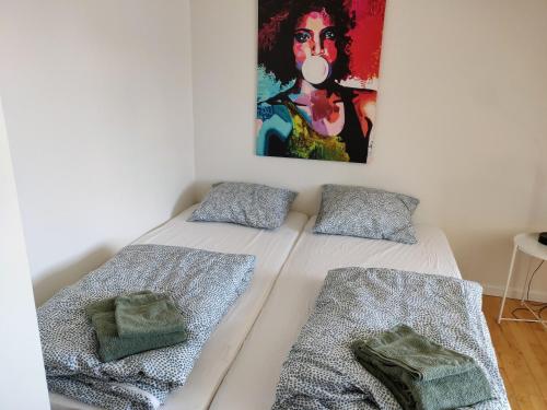 Dronninglund的住宿－Dronninglund Appartements，墙上画画的房间里设有两张床