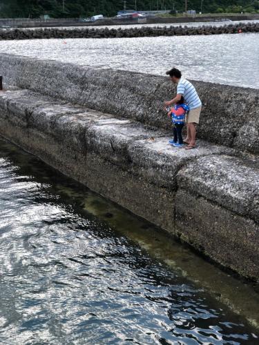 a man and a child looking at the water at Doublerainbow Resort Katsuura in Katsuura
