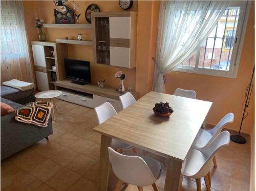 a living room with a table and white chairs at Casa Ana in Benaoján