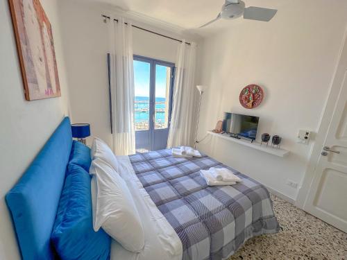 a bedroom with a blue bed and a window at La casa del pescatore in Sciacca