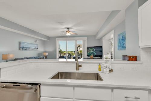 una cucina bianca con lavandino e finestra di Calypso 3-205 a Panama City Beach