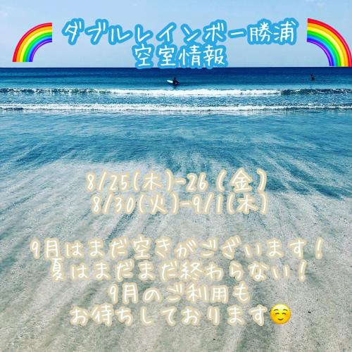 a sign on the beach with a rainbow in the background at Doublerainbow Resort Katsuura in Katsuura