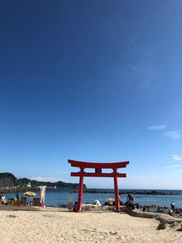 a torii gate on the beach near the water at Doublerainbow Resort Katsuura in Katsuura