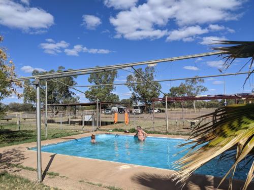 a couple of people in a swimming pool at Kulgera Roadhouse in Kulgera