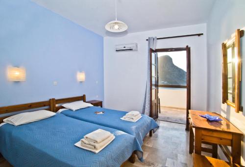 Dormitorio azul con cama y mesa en Pegasus, en Masouri