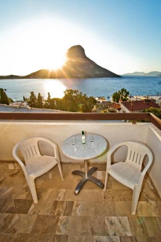 two chairs and a table on a balcony with the ocean at Pegasus in Masouri