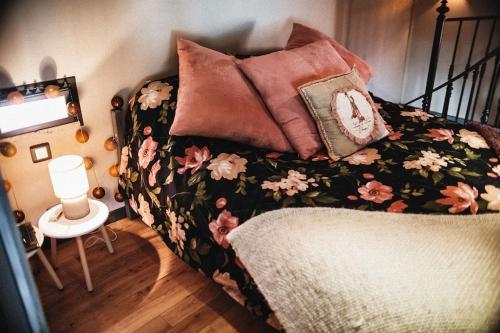 Un dormitorio con una cama con almohadas. en ''Mon instant présent'' de Miss.K Conciergerie, en Pierreclos