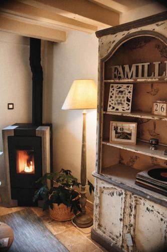 un salon avec une cheminée et une table avec une lampe dans l'établissement ''Mon instant présent'' de Miss.K Conciergerie, à Pierreclos