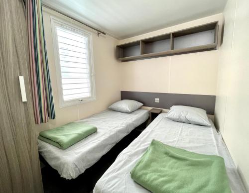 アルジェレス・シュル・メールにあるCamping Des Mimosasの窓付きの小さな部屋のベッド2台