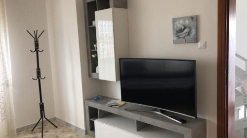 TV de pantalla plana en un stand en una habitación en Casa vacanza dai Nonni Ntoni, en Acquarica del Capo