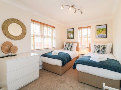 a bedroom with two beds and a mirror at Col du Crich in Matlock