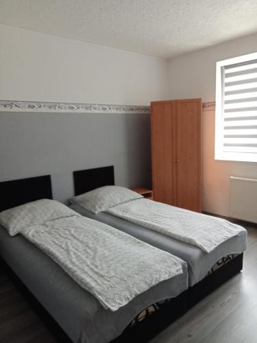 2 camas individuais num quarto com uma janela em Apartman Laguna em Balatonlelle