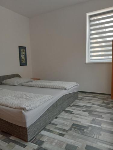 um quarto com uma cama num quarto com uma janela em Apartman Laguna em Balatonlelle