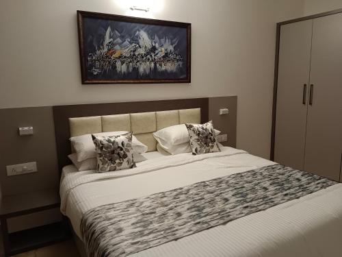 a bedroom with a bed with a picture on the wall at Lotus & Orchid Villas by Ramnath Homes in Sangolda