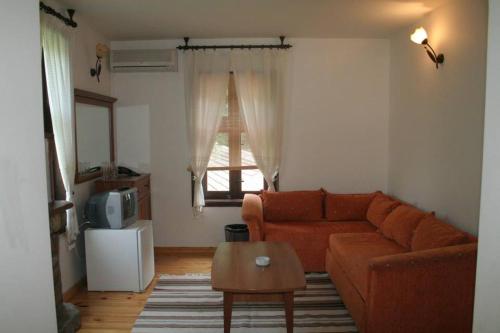 ein Wohnzimmer mit einem Sofa und einem Tisch in der Unterkunft Family Hotel Bile in Beli Osam