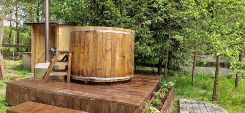 a wooden barrel sitting on top of a wooden stump at Ostoja Będzyn- Wypoczynek nad Pilicą in Piotrków Trybunalski