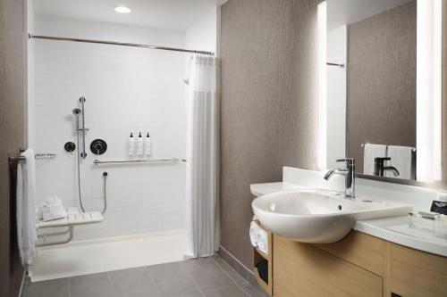a white bathroom with a sink and a shower at SpringHill Suites by Marriott Milpitas Silicon Valley in Milpitas