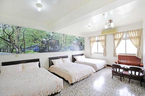 een slaapkamer met 2 bedden, een tafel en een piano bij Plum Inn 2 in Jiji