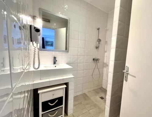 a bathroom with a sink and a shower with a mirror at Domaine Des Mimosas in Argelès-sur-Mer