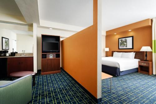 a hotel room with a bed and a flat screen tv at Fairfield Inn & Suites by Marriott San Francisco San Carlos in San Carlos