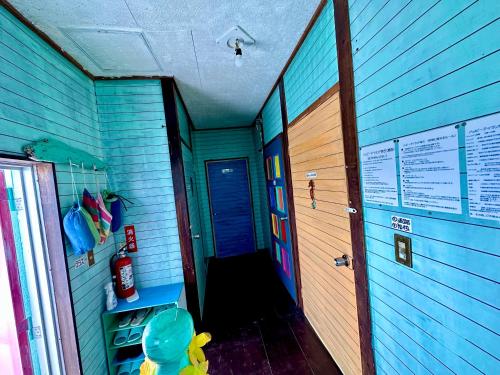 a hallway of a room with a blue wall at Happy Island Miyako in Miyako Island