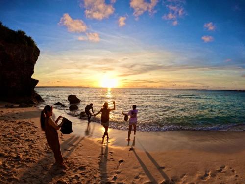 a group of people on the beach at sunset at Happy Island Miyako in Miyako Island