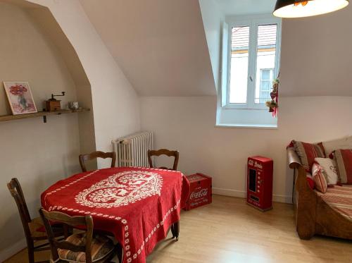 a bedroom with a table and a window and a couch at Charmante petite maison d’hôte, centre ville AUTUN in Autun