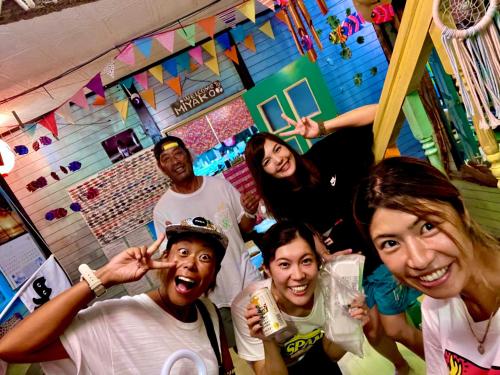 a group of people posing for a picture in a bar at Happy Island Miyako in Miyako Island