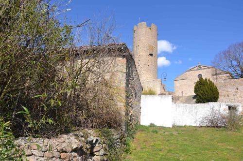 a building with a tower and a white fence at Maisonnette jardin jacuzzi au cœur de Chambles in Chambles