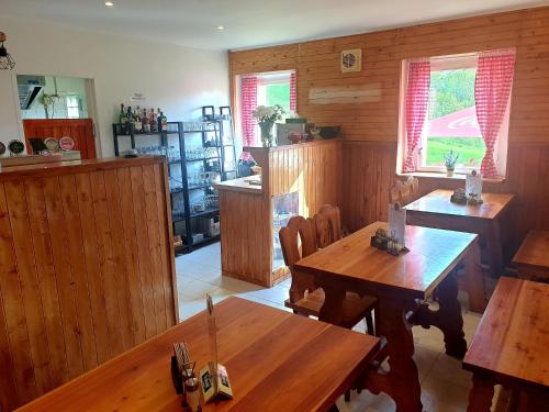 a kitchen with wooden walls and tables and windows at Penzion Tereza in Telnice