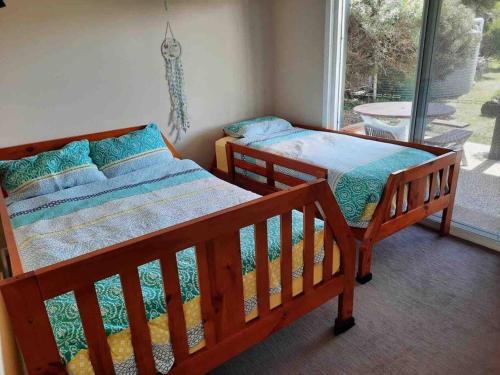 two beds in a room with a window at Surfside Escape in Surf Beach