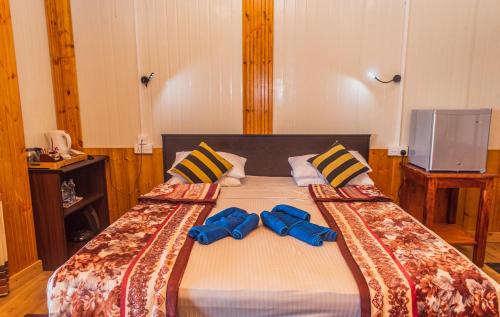 a bedroom with a bed with two bow ties on it at Ravana Range Ella in Ella
