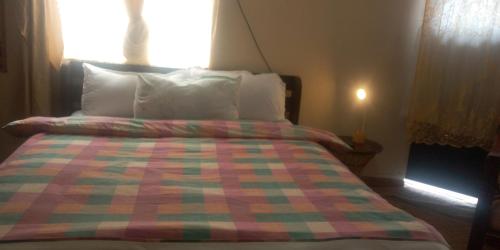 um quarto com uma cama com uma colcha colorida em The Buckingham Palace Nahashon Kimemia Studio em Nairobi