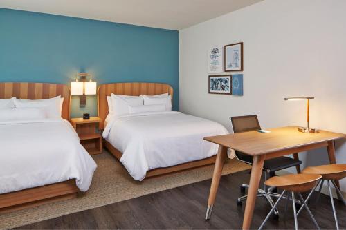 a hotel room with two beds and a desk and a table at Element Seattle Redmond in Redmond