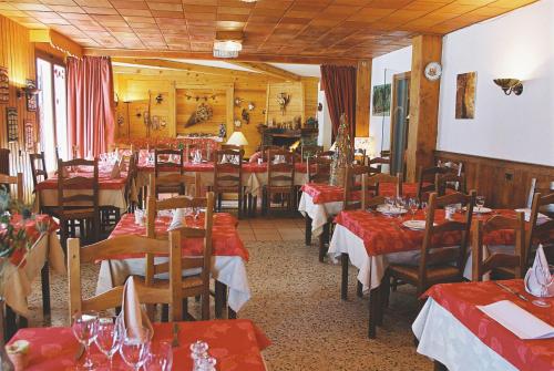 un restaurant avec des tables et des chaises avec une nappe rouge dans l'établissement Edelweiss, à Samoëns