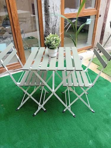 una mesa con 2 sillas y una maceta en Petit appartement avec terrasse en Guebwiller