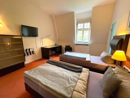 a hotel room with two beds and a desk at Das Kohnstamm in Königstein im Taunus