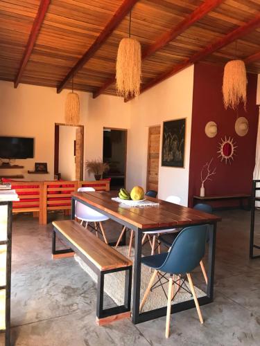 a dining room with a wooden table and chairs at RESIDENCE TSARA BE in Nosy Be