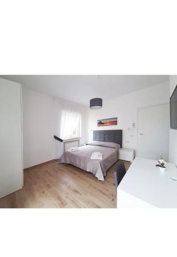 a white bedroom with a bed and a table at B&b CasaCapaldo in Naples
