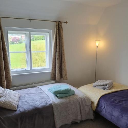 魏斯伯里的住宿－Priory Cottage，一间卧室设有一张床和一个窗口