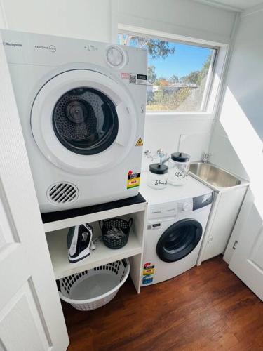 a washing machine and a sink in a small room at Savina Cottage in Stanthorpe
