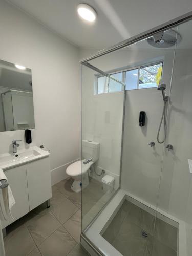 a bathroom with a shower and a toilet and a sink at Busselton Jetty Chalets in Busselton