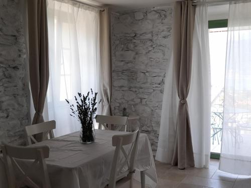 una mesa blanca con sillas y un jarrón de flores. en APE BIANCA - Appartamento Lavanda, en Colico
