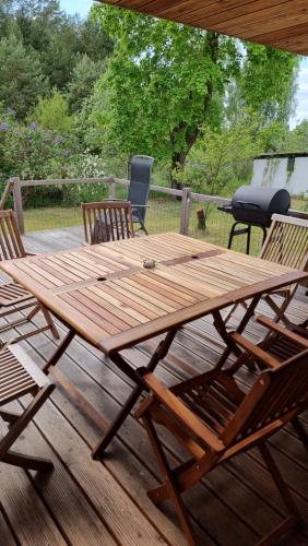 a wooden picnic table and chairs on a deck at Mecklenburgische Seenplatte - FH mit optionalem Steg und Ruderboot in Großzerlang