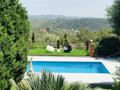 een zwembad in een tuin met uitzicht bij Villa Wanderlust Sitges Hills. Exclusive pool. in Olivella