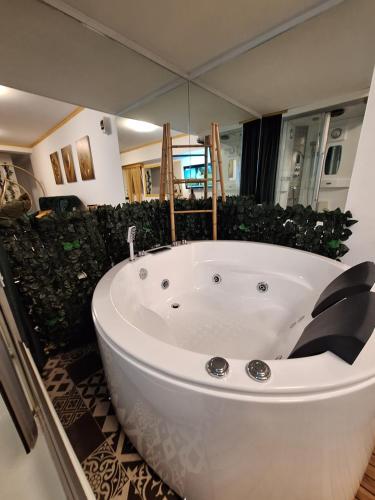 a large white bath tub in a bathroom at Guest House Villa Lord in Novi Sad