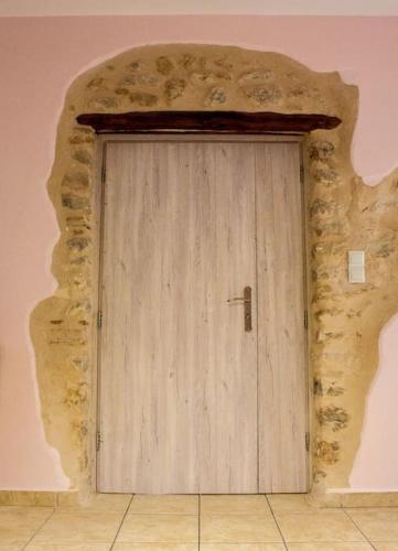 a wooden door in a room with a stone wall at Lucy's Home in Riglia
