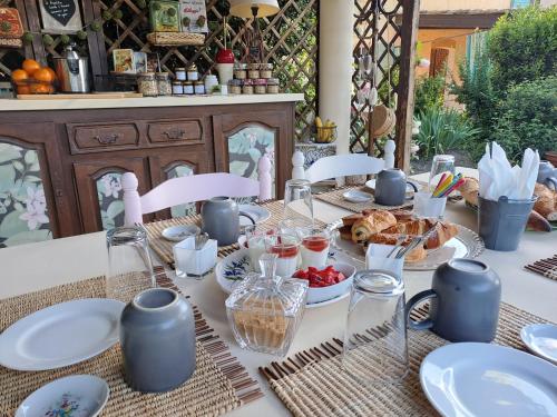 een tafel met borden en glazen en eten erop bij Mas Campagne Etoilée in Caderousse
